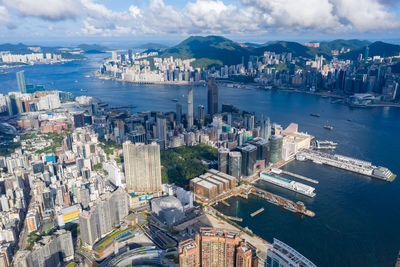 High angle view of city buildings against cloudy sky