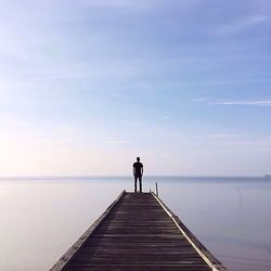 Rear view of man standing on pier