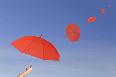 Low angle view of person paragliding against clear blue sky