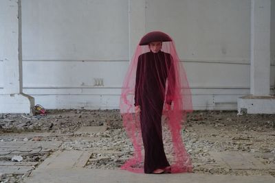 Low section of woman standing against wall