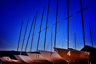 Low angle view of boats moored against clear blue sky