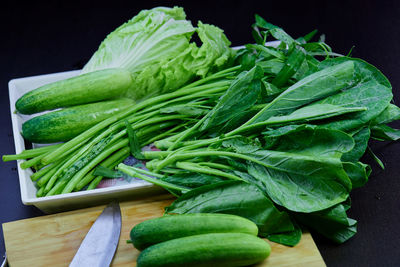 Close-up the variety of organic fresh vegetables in plastic bowl on black background