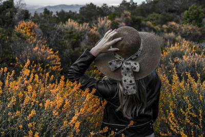 Full length of man standing by flowering plants