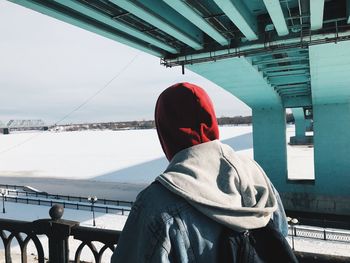 Rear view of man wearing warm clothing in city during winter