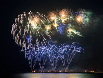 Firework display against sky at night