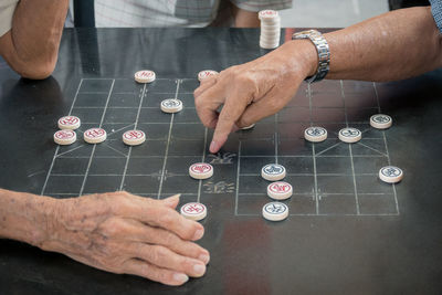 Cropped image of people playing chinese chess