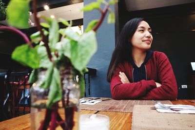 Thoughtful young woman sitting at table in restaurant