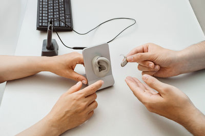 Cropped hands of woman using smart phone on table