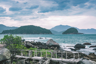 Scenic view of sea and mountains against sky