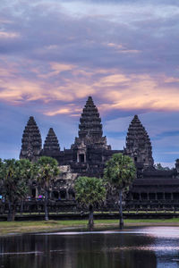 Temple against buildings at sunset