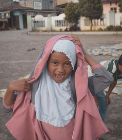 Portrait of young woman standing in city