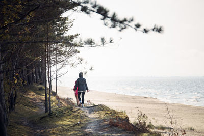 Rear view of man walking on beach