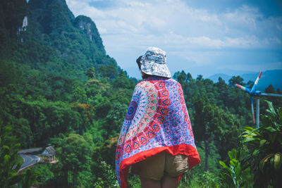 Rear view of woman standing against sky