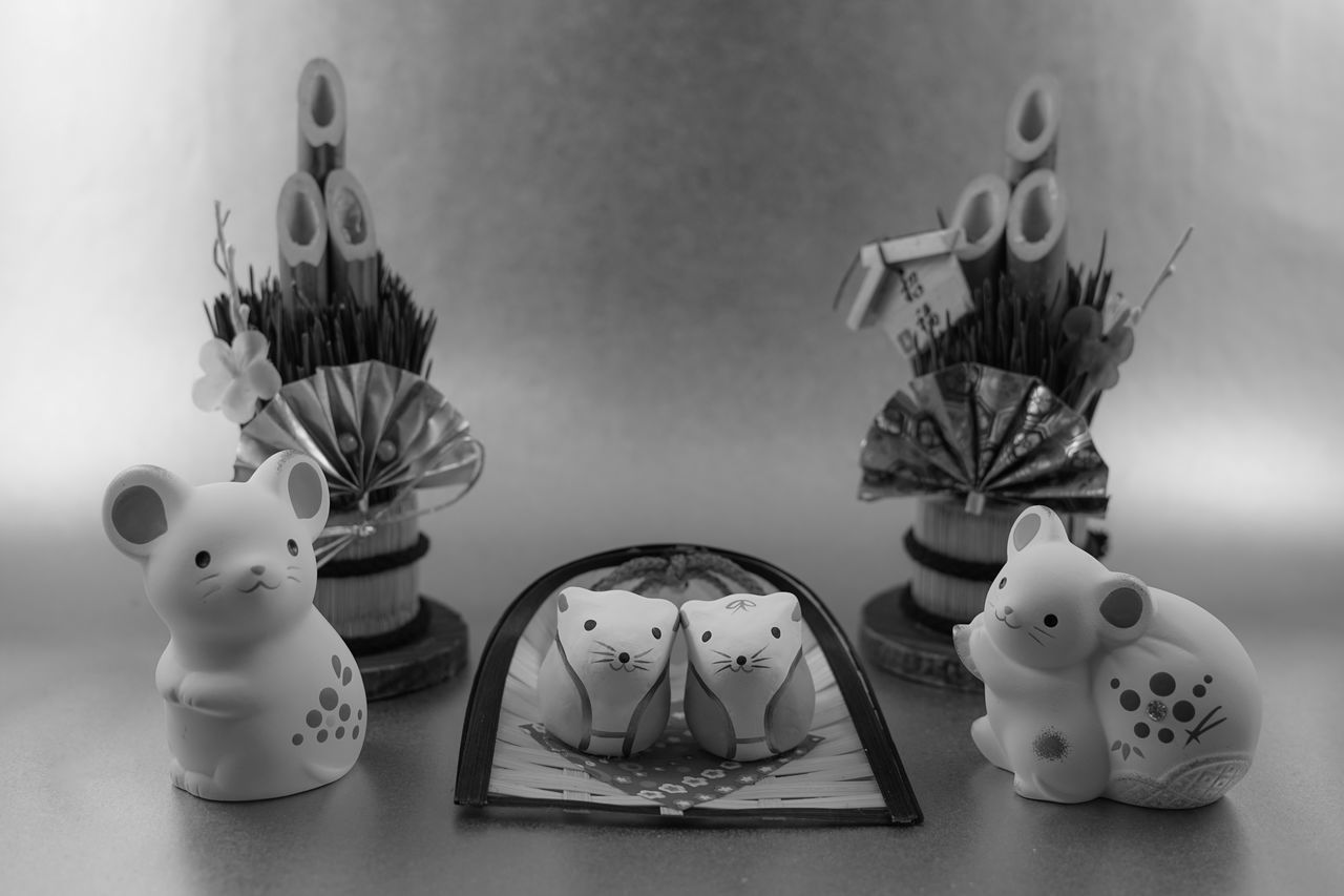 black and white, white, monochrome photography, monochrome, animal representation, indoors, representation, no people, cartoon, black, still life, table, still life photography, craft, group of objects, creativity, animal