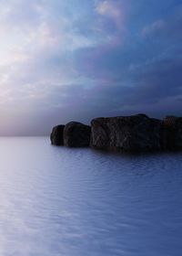 Rocks in sea against sky