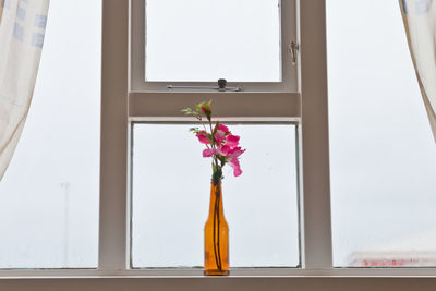 Close-up of flower vase on window sill