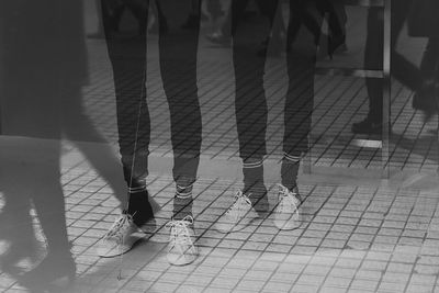 Low section of people standing on tiled floor