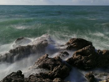 View of waves breaking on rocks