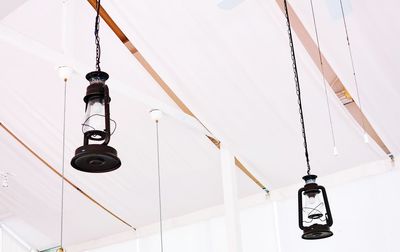 Low angle view of electric lamp hanging against ceiling