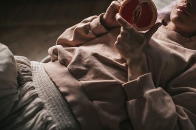 Midsection of woman holding grapefruit