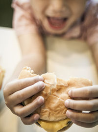 High angle view of boy eating burger at table