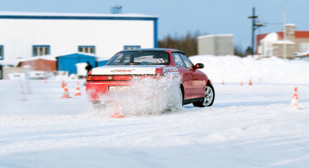 CLOSE-UP OF CAR ON SNOWY ROAD