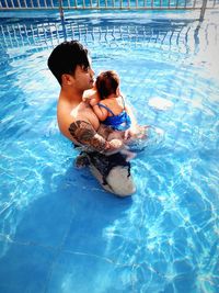 High angle view of mother and daughter in swimming pool