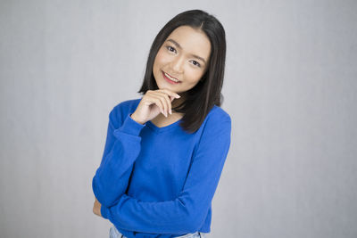 Portrait of a smiling young woman against white background