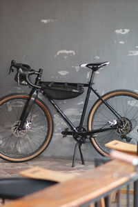 Bicycle parked by railing against wall