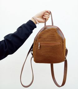 Close-up of hand holding umbrella against white background