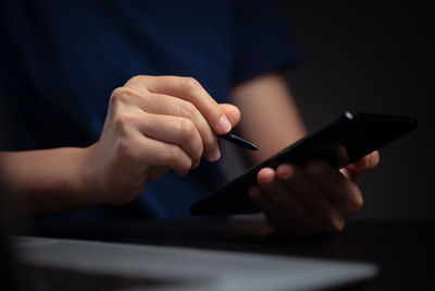 Midsection of man using mobile phone