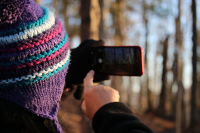 Close-up of person photographing with mobile phone in winter