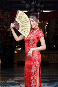 Midsection of woman holding red umbrella against blurred background