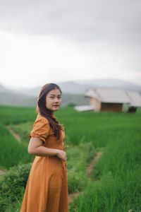 Woman standing on field against sky