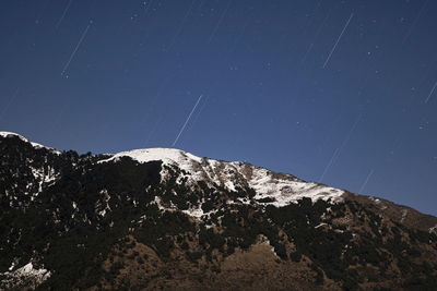 Scenic view of snowcapped mountains against sky at night