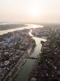 High angle view of city by river against sky