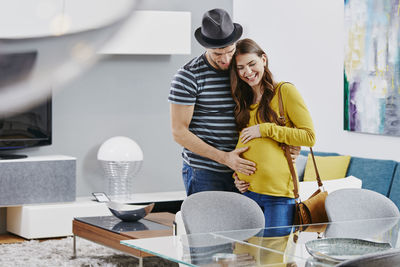 Couple with pregnant woman in furniture store looking at dining table