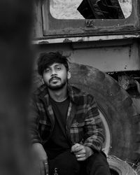 Portrait of young man sitting outdoors