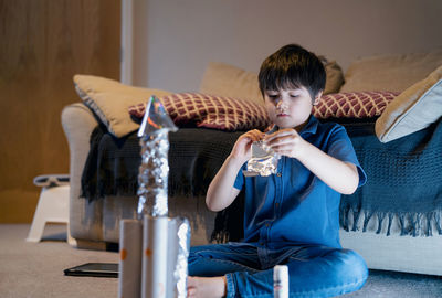 Boy sitting on sofa at home