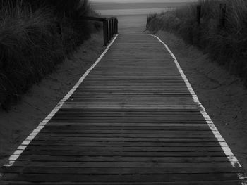 Empty walkway amidst field