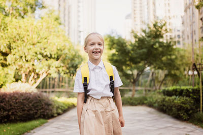 Back to school. little girl with yellow backpack from elementary school outdoor