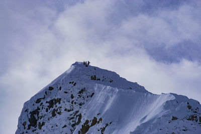 Low angle view of hikers on mount matier against cloudy sky