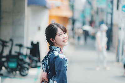 Portrait of woman standing on street in city