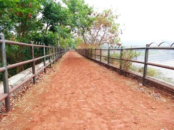 Footbridge over river against clear sky