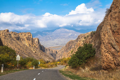 Road leading towards mountains against sky