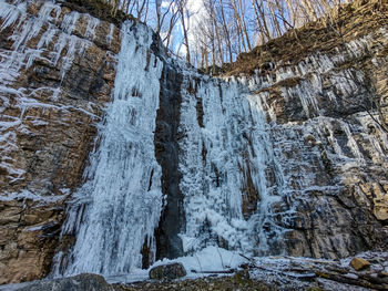 Low angle view of icicles on rocks in winter