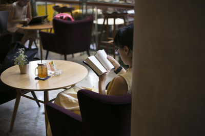Woman sitting by table in cafe