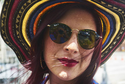 Portrait of young woman wearing sunglasses and hat