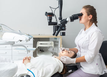 Side view of doctor examining patient in clinic