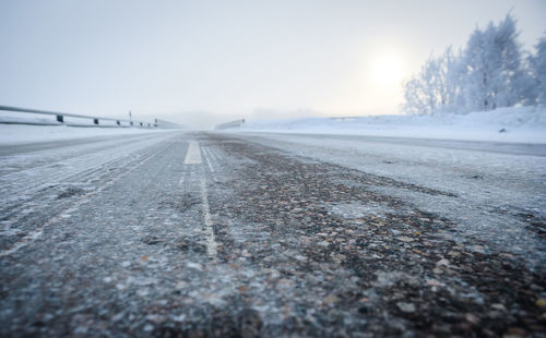 Surface level of road against clear sky during winter